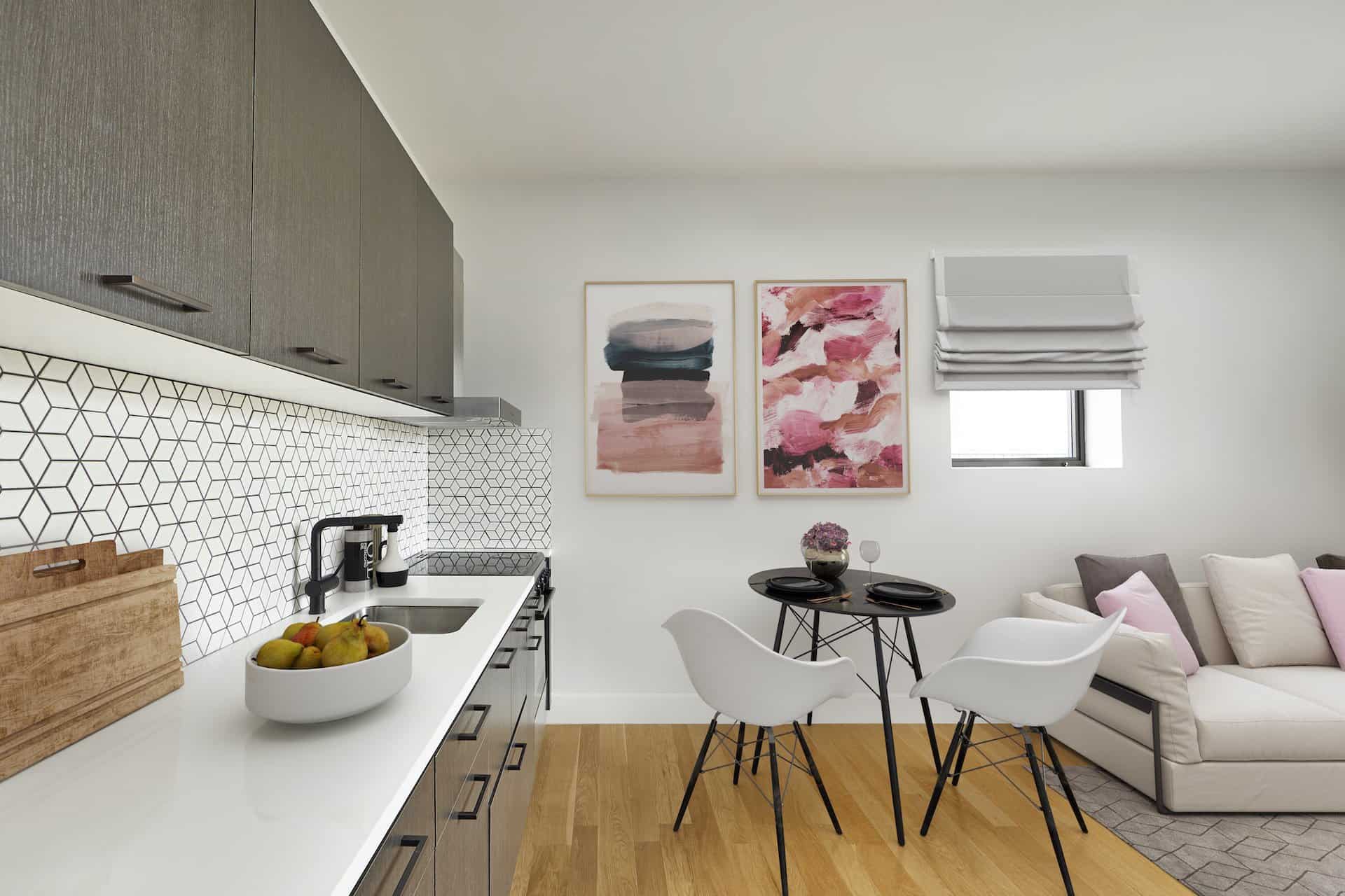 Kitchen in a studio apartment at 101 East 10th Street in New York. White kitchen counter, wood cabinets, oven & dining table.