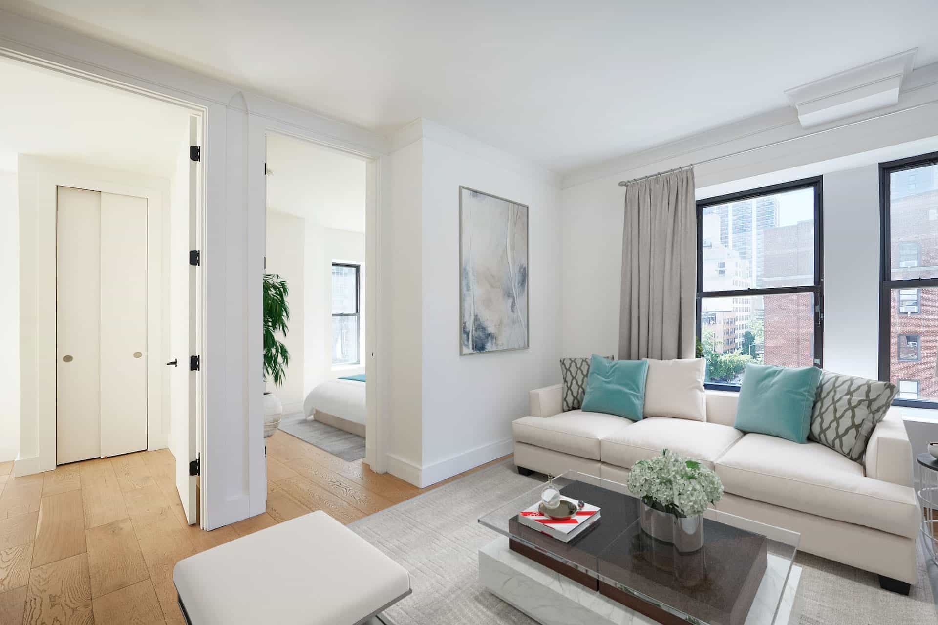 Living room at 401 East 50th Street apartments in Midtown East with two windows, hardwood floors, and living room furniture.