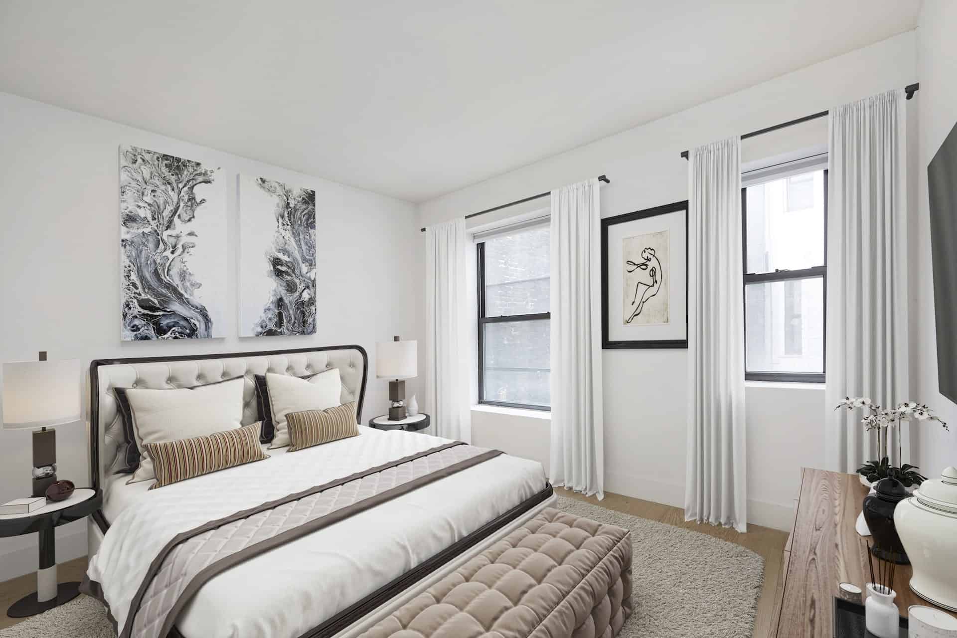 Bedroom at 401 East 50th Street apartments in Midtown East with a king bed, side tables, hardwood floors, and two windows.