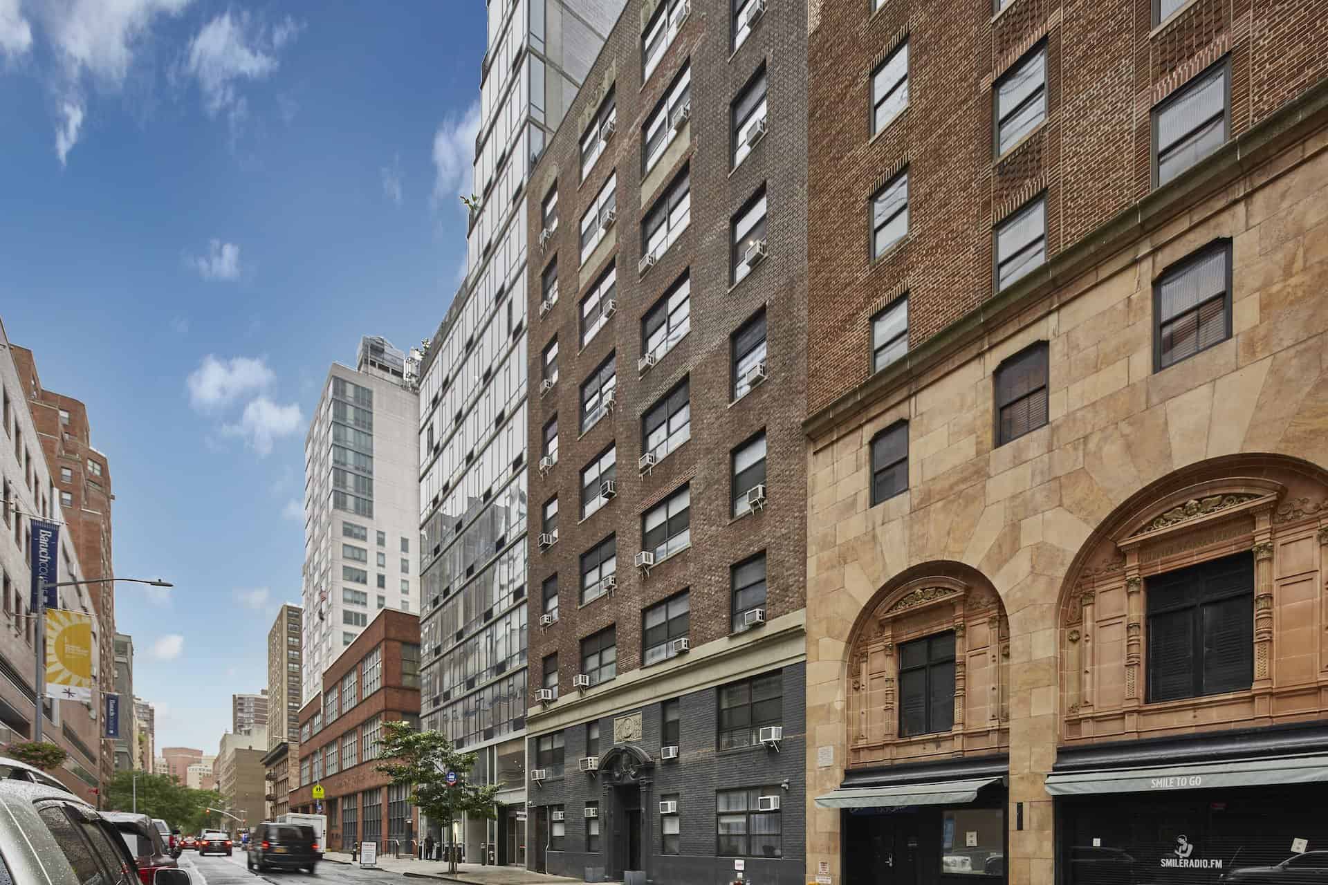 Exterior of 144 East 24th Street apartments in Kips Bay. Tall brick residential building with arched entryway.
