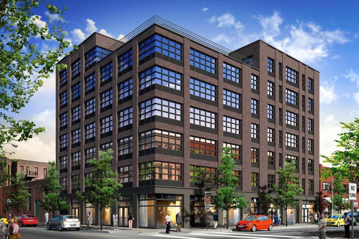 Exterior of 66 Ainslie Street apartments in Brooklyn, NY with industrial finishes and businesses on the ground floor.