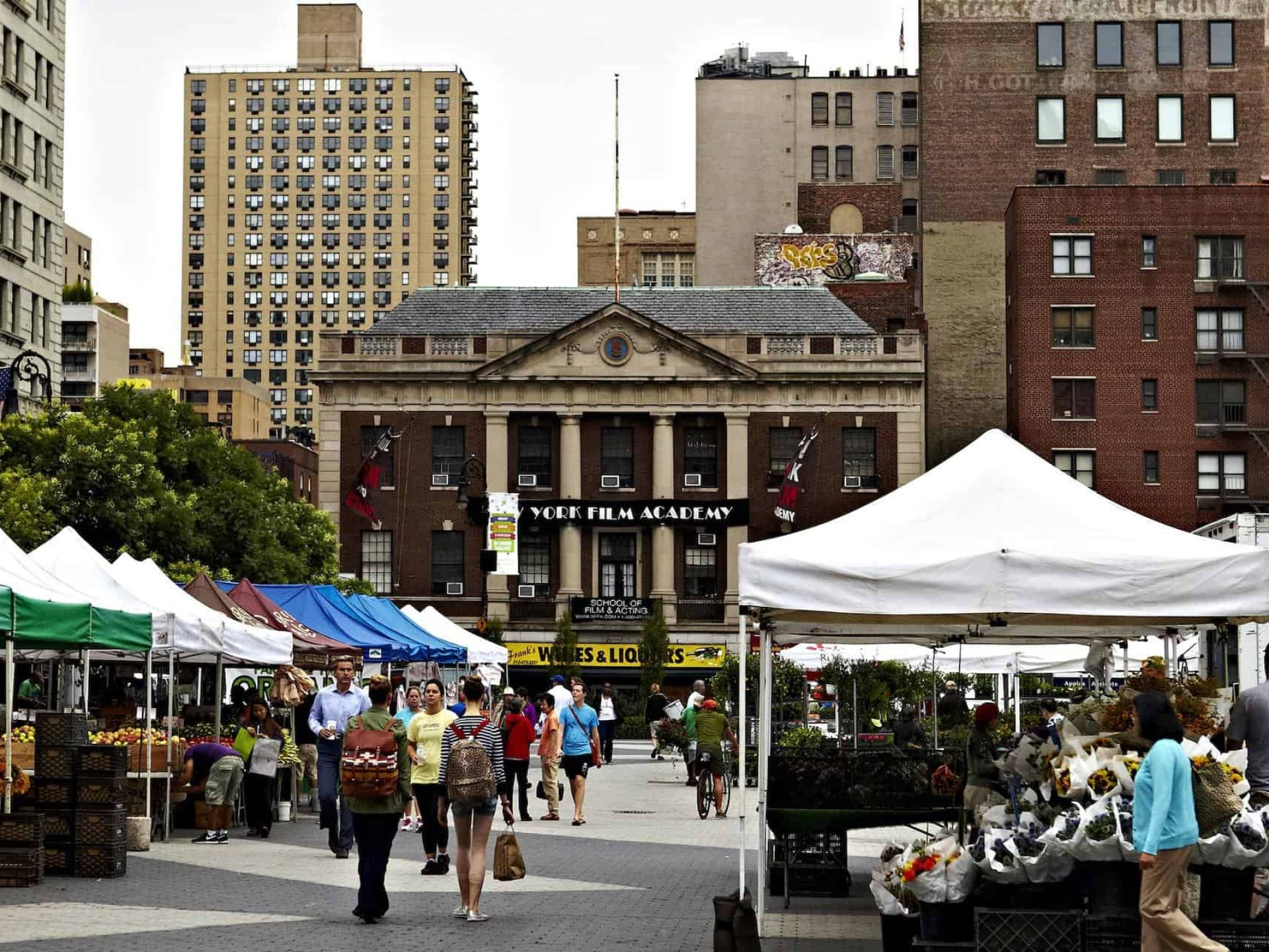 Outdoor market in New York's East Village during in front of the New York Film Academy with pop up tents and people walking.