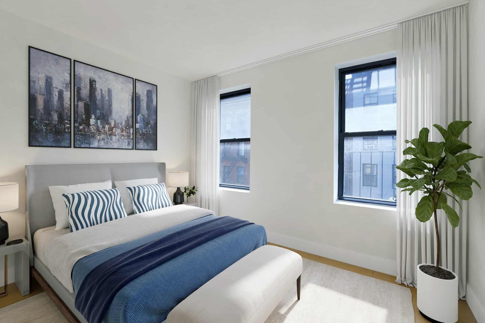 Bedroom at 151-153 Ludlow Street apartments with a queen size bed, headboard, side tables, two windows and hardwood floors.