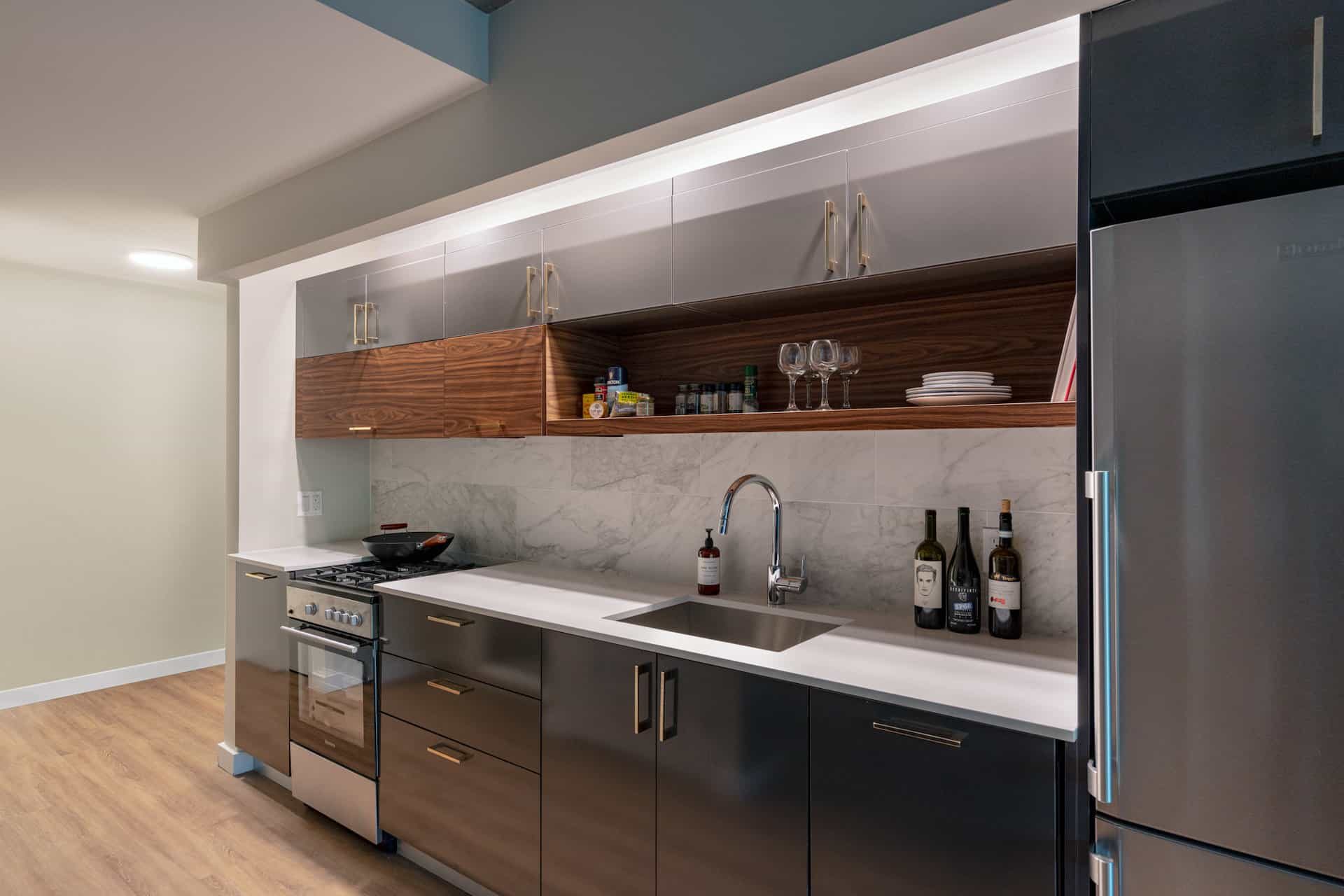 Kitchen at 222 Johnson Avenue apartments in Brooklyn with stone countertops, stainless steel appliances and hardwood floors.