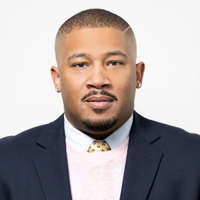 Head shot of Abode Residential licensed real estate agent Sean Fuller. Male with black hair, white sweater and blue jacket.